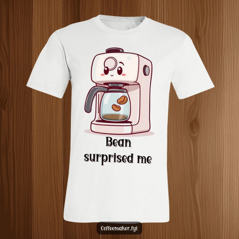 Funny t-shirt featuring a surprised coffee maker machine reacting to a tiny coffee bean leaping out unexpectedly, creating a playful scene.